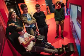 Experience science: Visitors test the exhibit (© Photo: Ilja C. Hendel/Wissenschaft im Dialog). Junge Besucher des MS-Wisschenschaft Science Center, die an und um eine Fahrsimulation sitzen