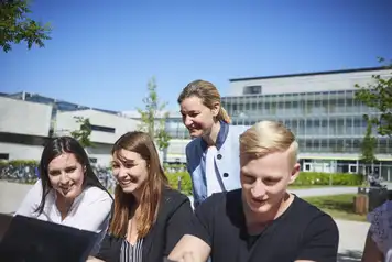 Professorin mit Studierenden Freiluftvorlesung