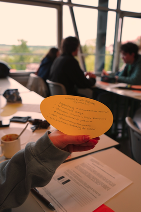 Wishes for the school of the future (Photo: THI). Bild eines Zettels mit Wünschen für die Schule, den eine Person im Klassenzimmer in der Hand hält
