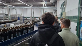 Personen neben der Abfüllanlage der Brauerei Herrenbräu.
