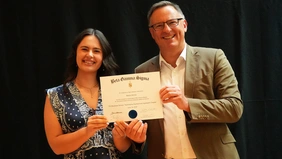 A woman and a man present a certificate.
