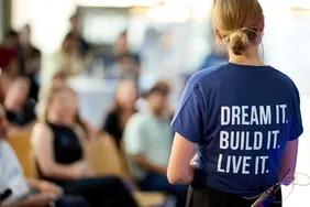 "Dream it. Build it. Live it." Das ist das Motto des Center of Entrepreneurship der THI (Foto: CoE). Bild einer Person mit Thirt, dass das Moto des CoE als Print auf dem Rücken hat: "Dream it. Built it. Live it."