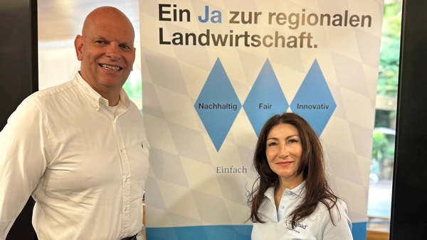 Ein Mann und eine Frau stehen vor einer Werbetafel.